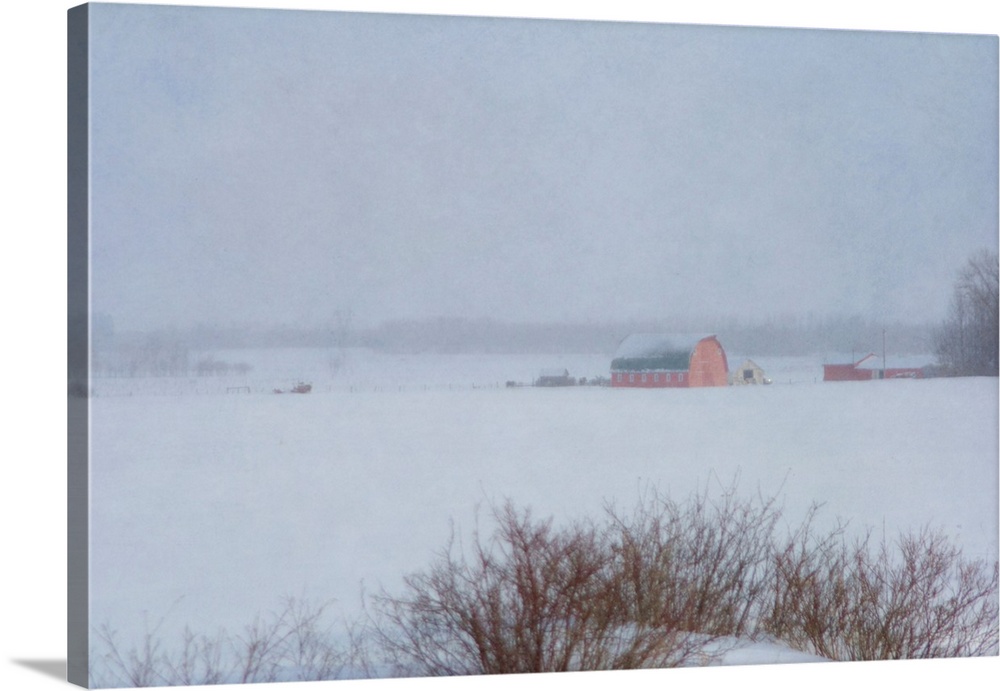 Pictorial photograph of a red country barn on a farm in winter during a snowstorm.