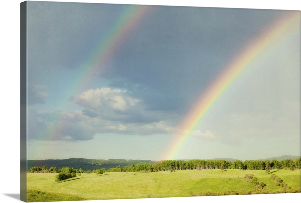 Photograph of a lush green landscape with a double rainbow overhead.