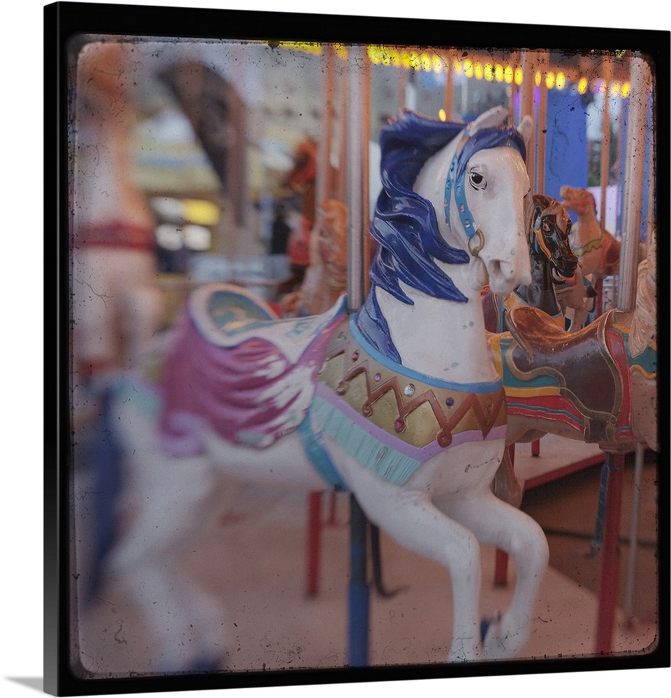 Square image of a horse on a carousal with a blurred focus.