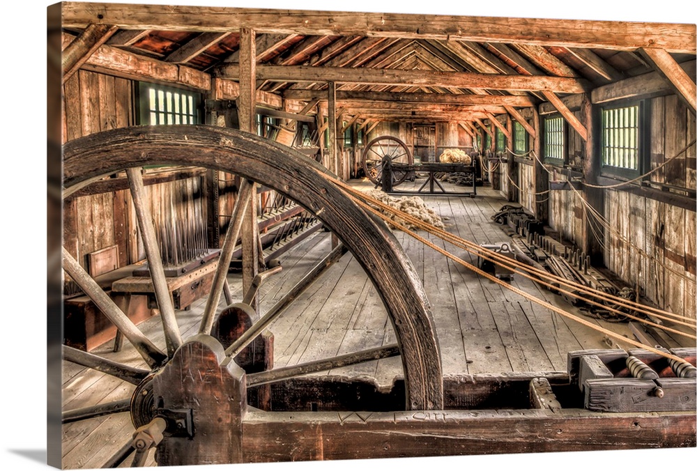 The interior of an old rope factory, with large wooden wheels.
