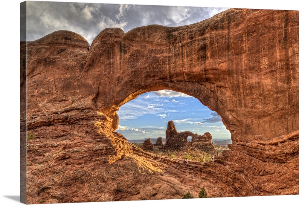Photograph of a large rock formation seen through a rock arch.