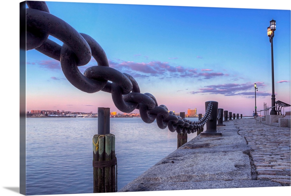 Twilight on the Boston Fan Pier, with iron chains and street lights.