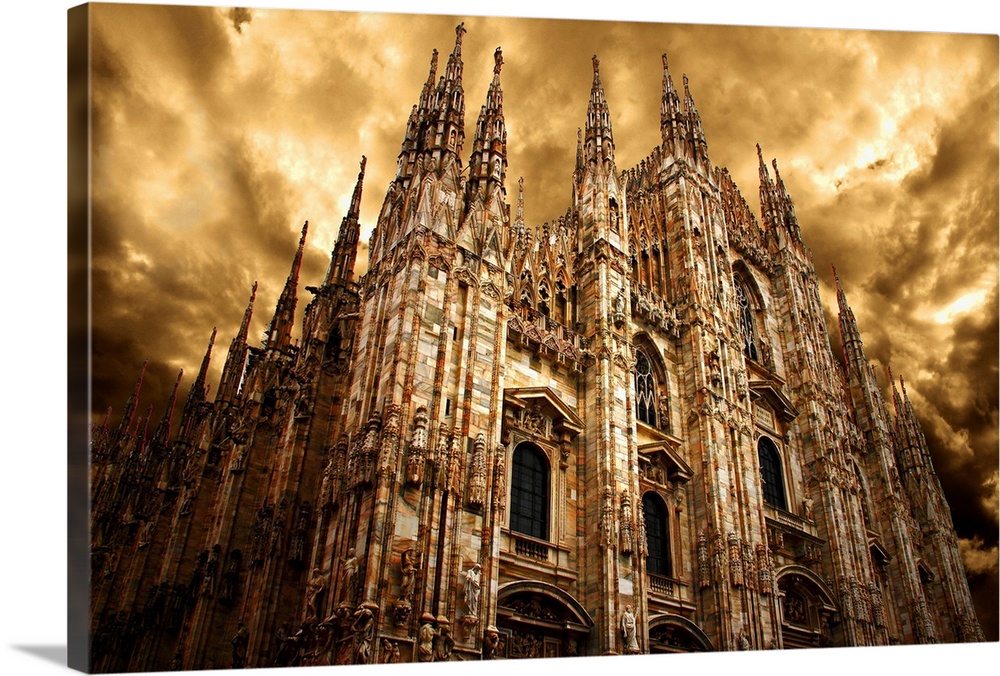 Milan Cathedral under a cloudy sky in golden light.