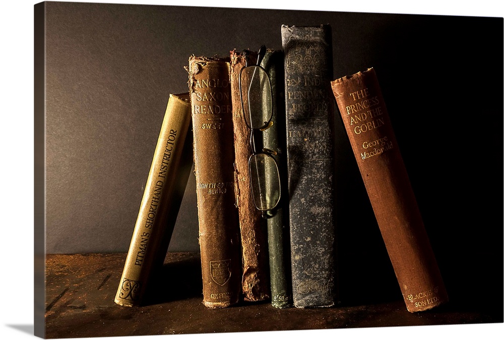 A collection of old, worn books leaning together.