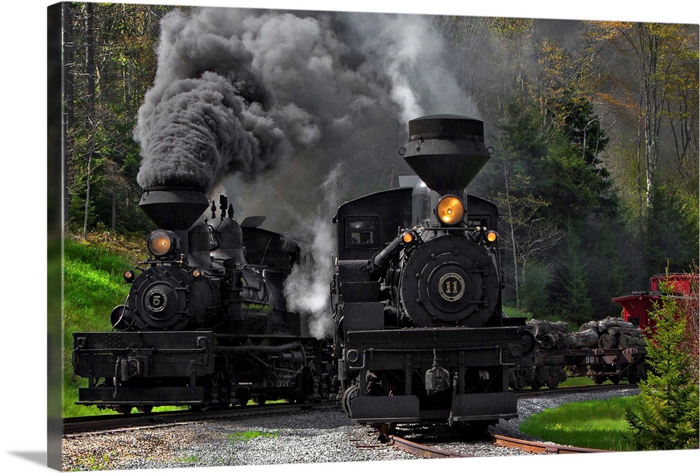 Two large locomotives on the tracks with smoke billowing out of their smokestacks.