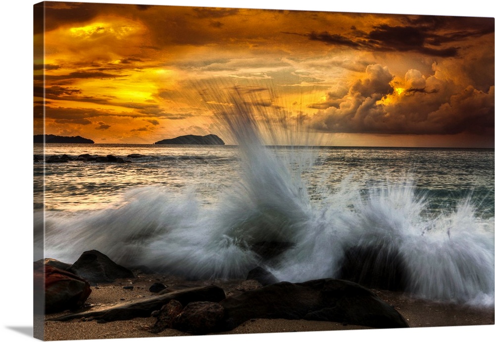 Waves crashing on the rocky shore at sunset.