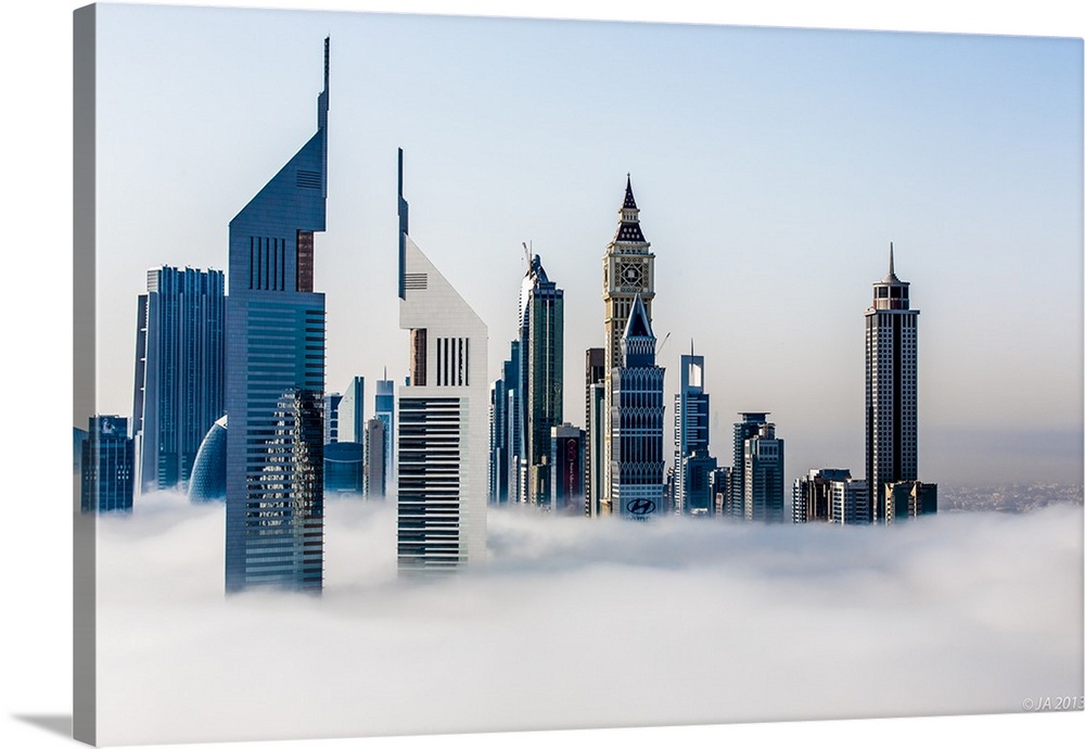 Jumeirah Emirates Towers stand tall in the fog with the Arabian Gulf in the background.
