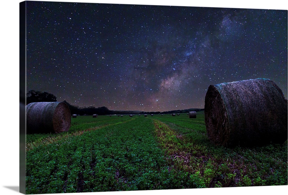 Hay field in Nebraska under the beautiful night sky, with the Milky Way visible.