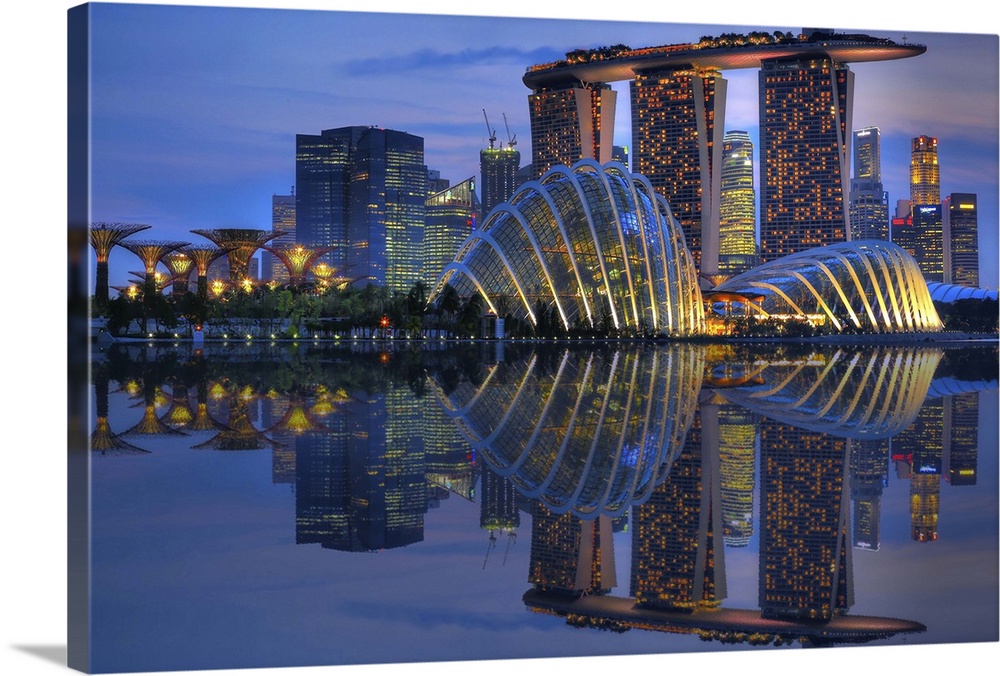 Singapore city skyline casting its reflection in the water below at sunset.