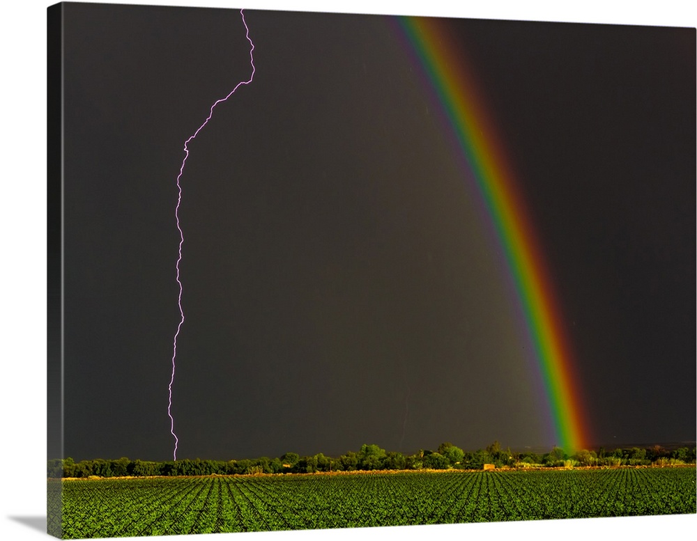 Lightning strike and a rainbow in the sky over Kanoneiland, South Africa.