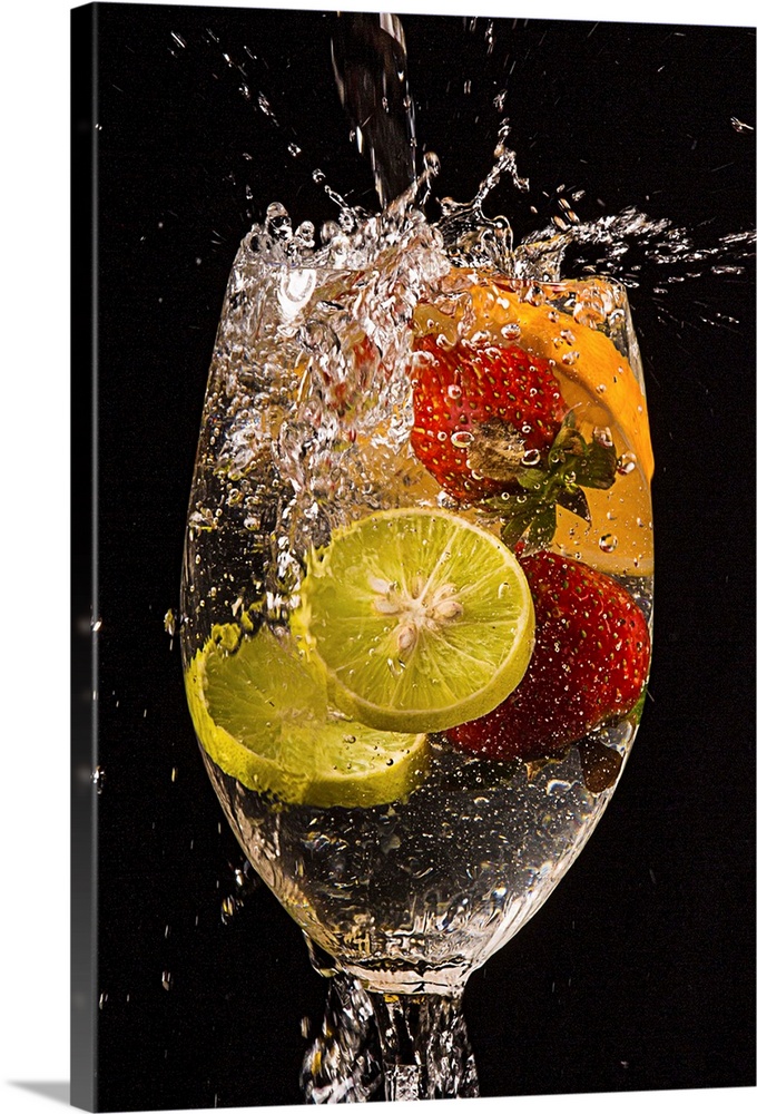 Slices of lemons and oranges and whole strawberries splashing into a glass of water.