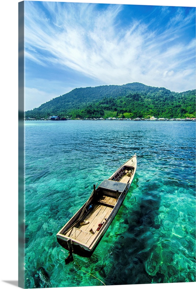 A boat on the clear water near beautiful Letung Island, Indonesia.