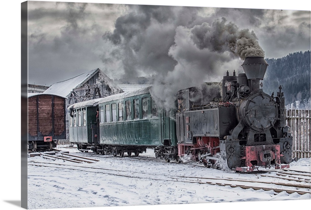 A steam locomotive going down the tracks in the snow.