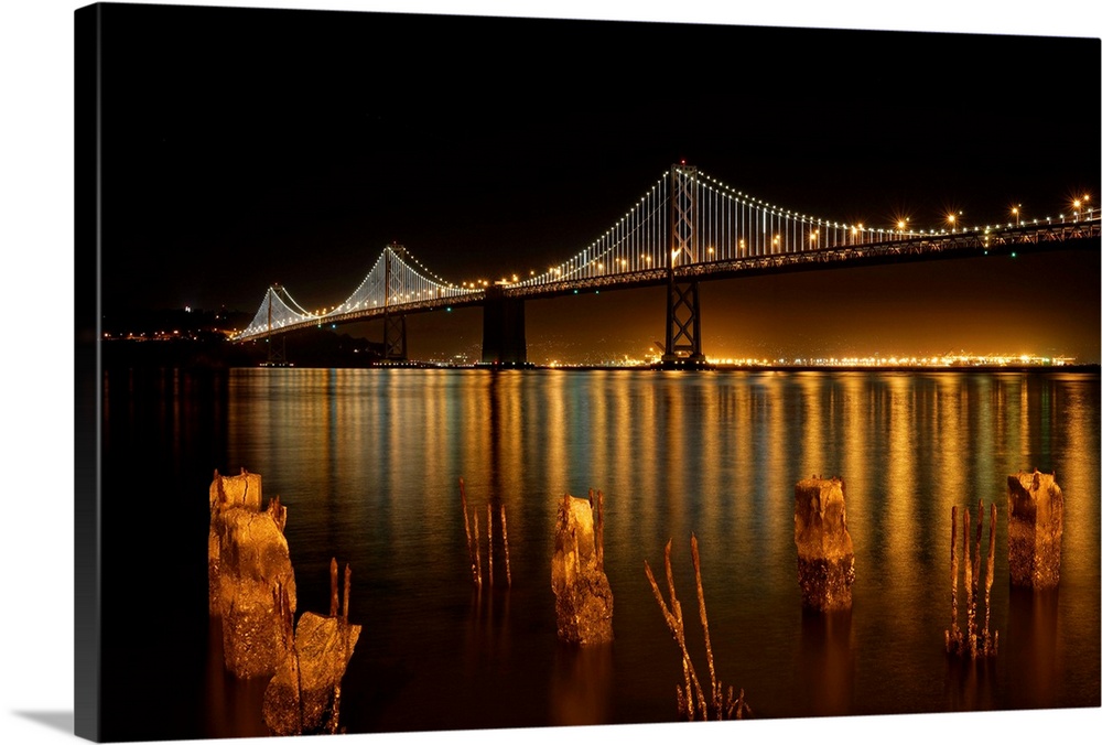 The Bay Bridge in San Francisco lit up at night, as seen from the shore.