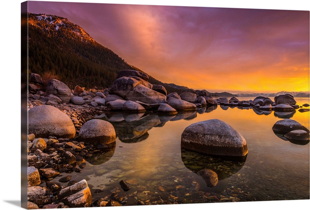 Round rocks in the shallow waters of Lake Tahoe in the Sierra Nevada Mountains at sunset.