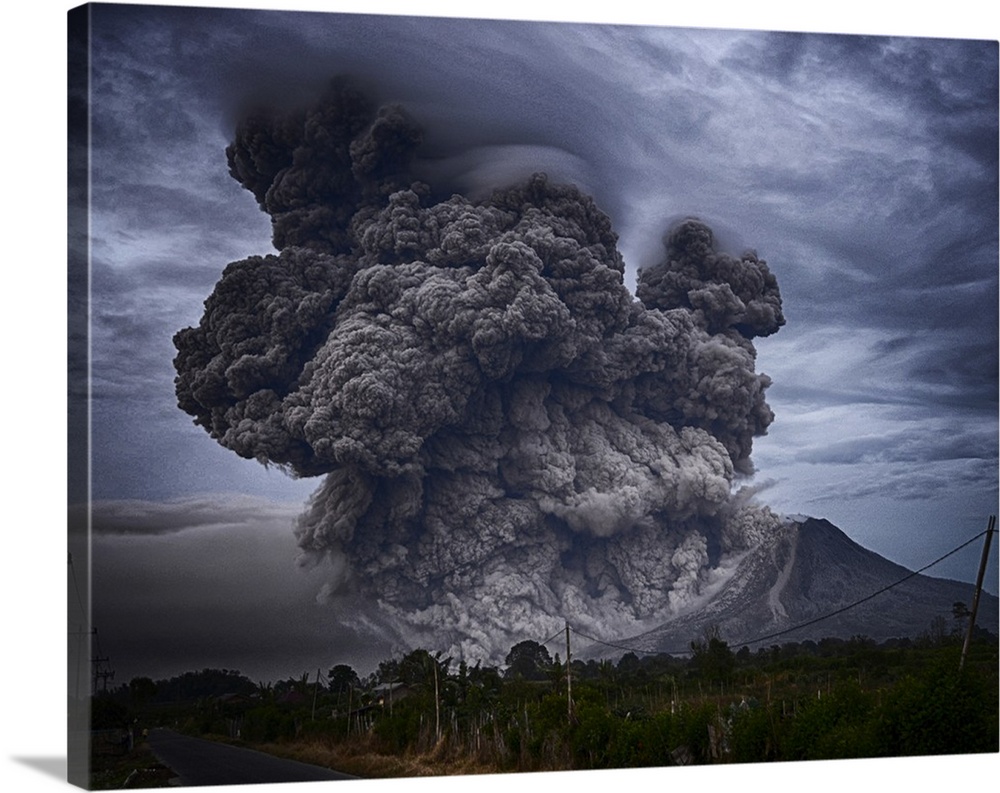 Dramatic photograph of an intense plume of smoke rising from the mouth of a volcano in Indonesia.