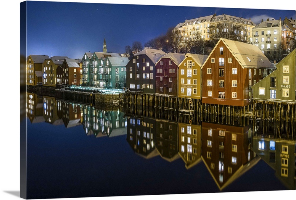 Photograph of a Norwegian houses reflecting in water below.