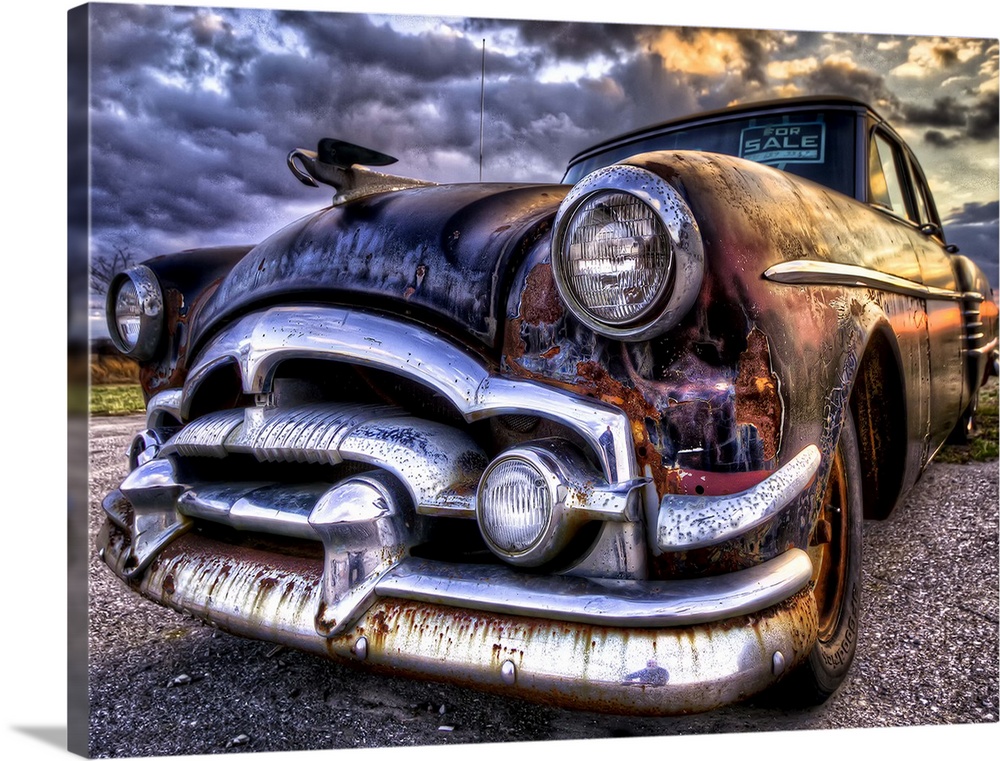 An old, rusted '54 Packard car with sunset light.