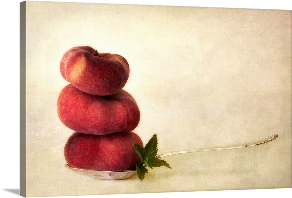 Balancing act with vineyard peaches and some peppermint leaves on a tablespoon