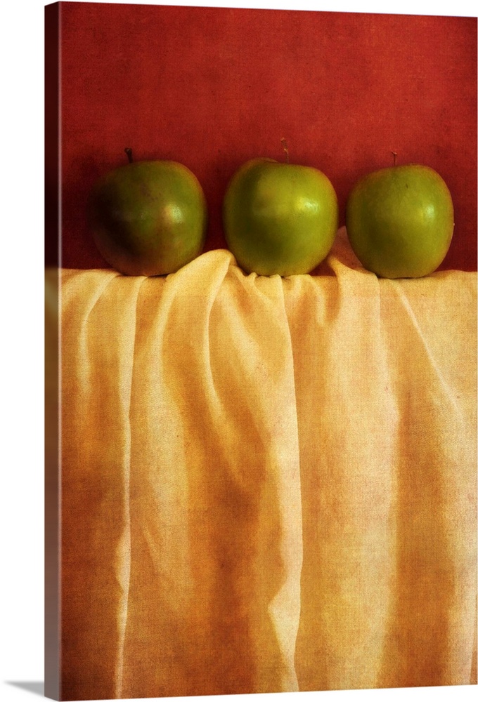 Still life with three granny smith apples against red background