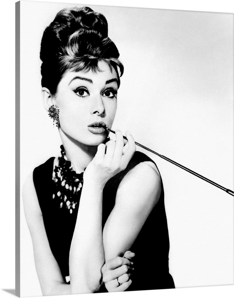 This wall art is a portrait photograph of the Hollywood Icon character Holly Golightly in her signature black dress, jewel...