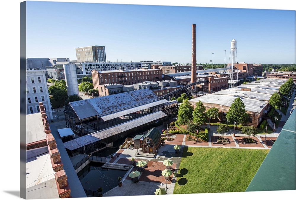 Early morning sunlight shining on the redeveloped American Tobacco Historic District, with the Lucky Strike smokestack and...