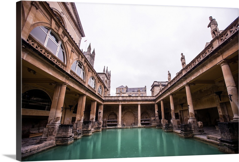 Photograph of the Great Bath in England with gray, cloudy skies above, Bath, England, UK