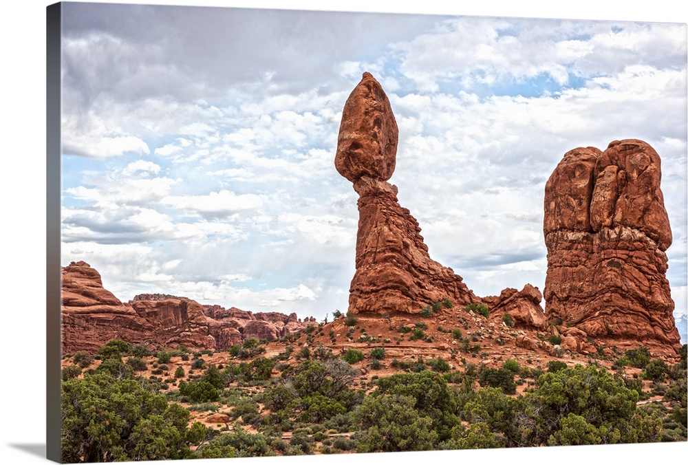 Balanced Rock standing next to a sandstone rock formation under a cloudy sky, Arches National Park, Utah.