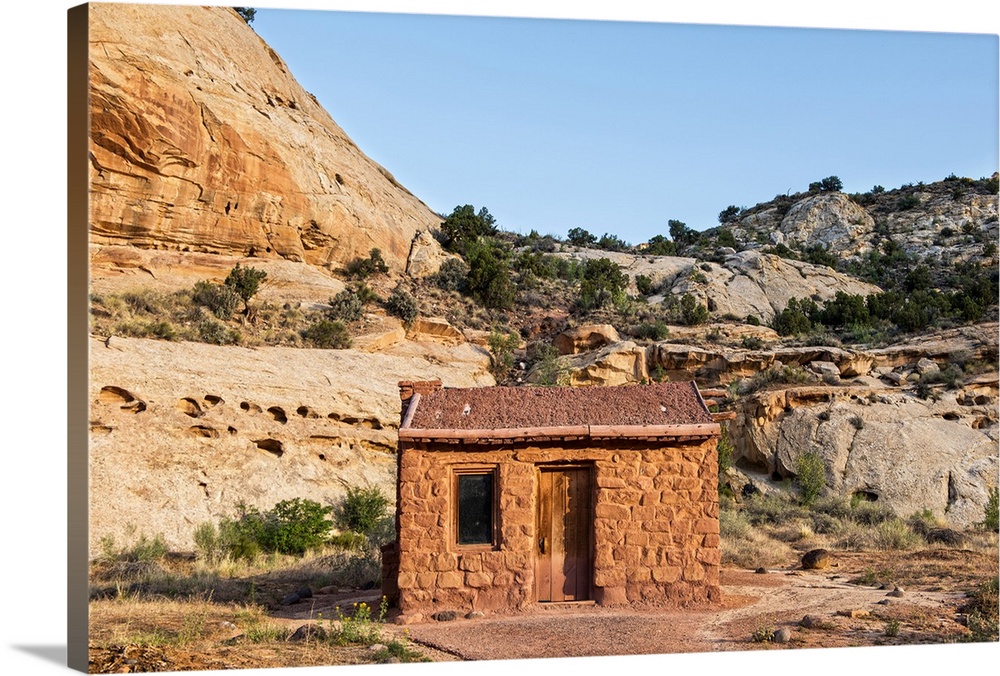 Behunin Cabin with the cliffs of the Waterpocket Fold overlooking it at Capitol Reef National Park in Utah.