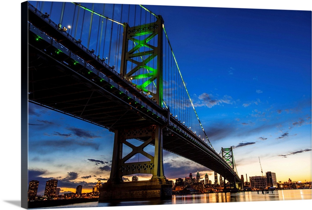 After the sun goes down, the bridge's towers and curving suspension cables emerge with a colorful phosphorescent glow.