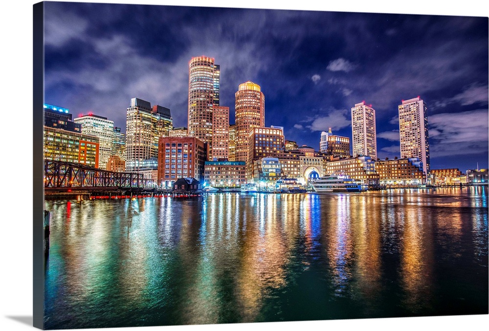 The lights of downtown Boston reflect upon Massachusetts Bay.