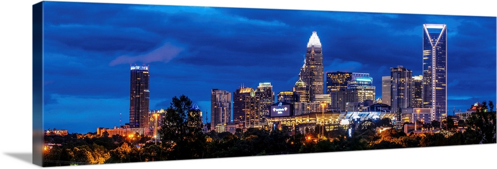 Horizontal image of Charlotte, North Carolina at night with clouds in the sky.