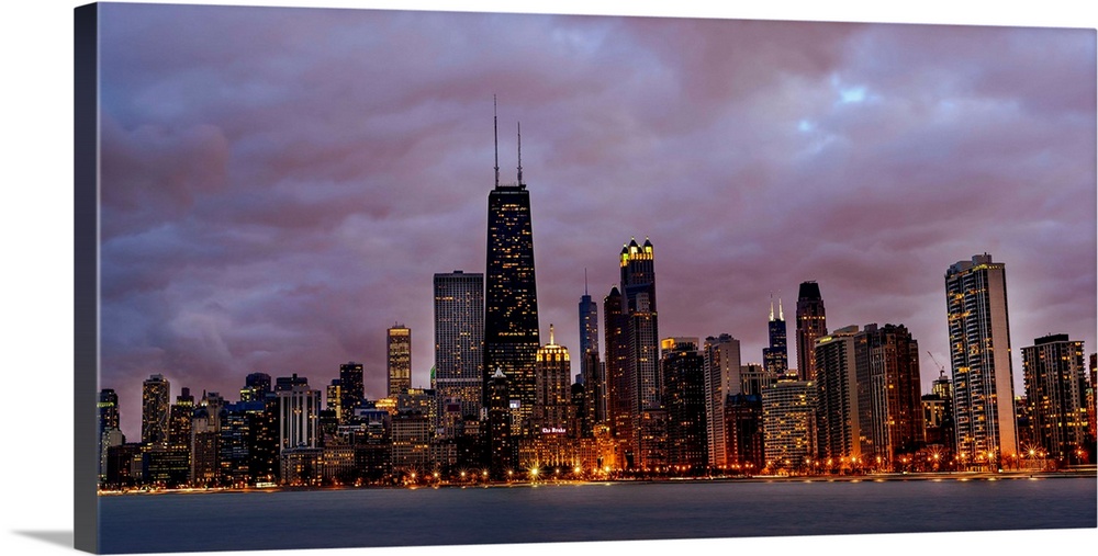Panoramic Photo of Chicago skyline at night under dramatic clouds.