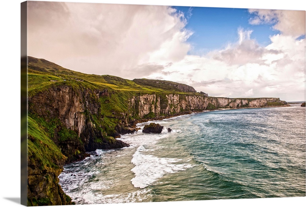 Landscape photograph of the picturesque Cliffs of Moher with a cloudy sky above, located at the southwestern edge of the B...