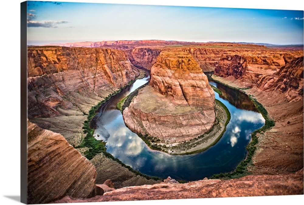 Landscape photograph of Horseshoe Bend in Page, Arizona with blue cloudy skies reflecting into the Colorado River and cont...