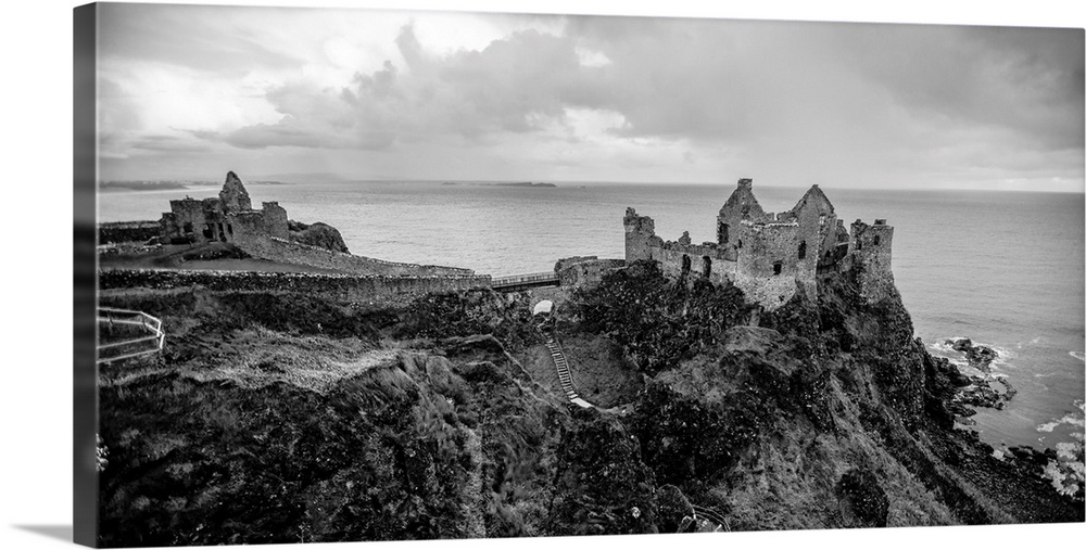 Landscape photograph of Dunluce Castle next to the ocean, taken from a higher point.