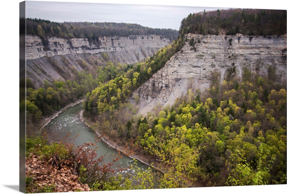 Landscape photograph of the Genesee River bending around large rock formations at Letchworth State Park in New York.