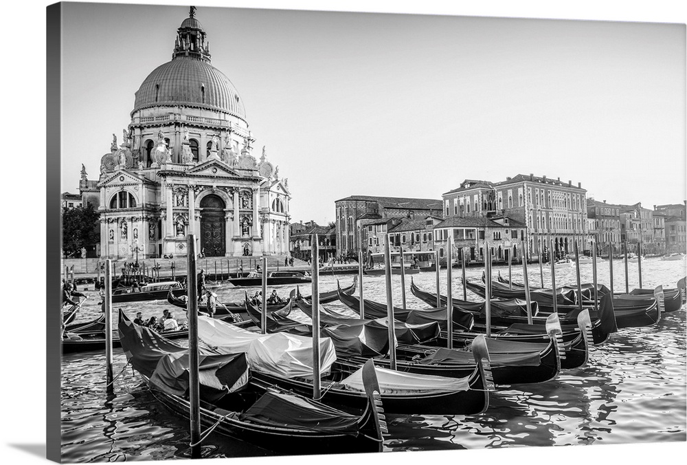 Photograph of gondolas lined up in a row in front of Santa Maria della Salute, Venice, Italy, Europe.