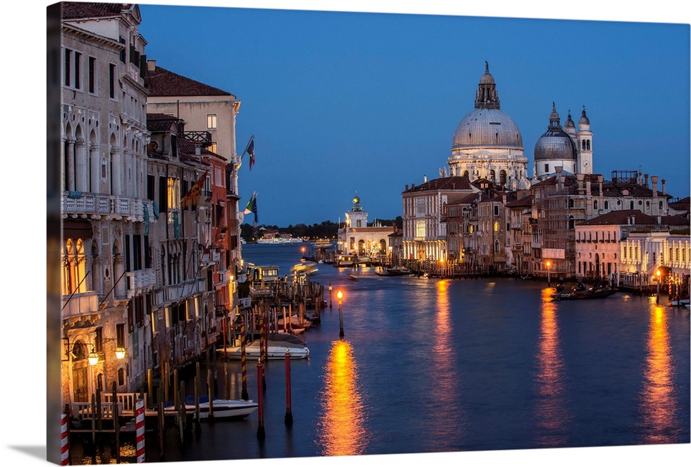 Photograph of Grand Canal lit up at night with the Santa Maria della Salute in the background.