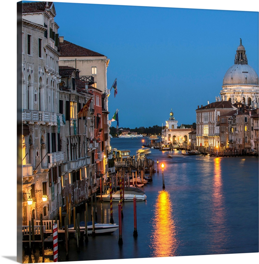 Square photograph of Grand Canal lit up at night with the Santa Maria della Salute in the background.