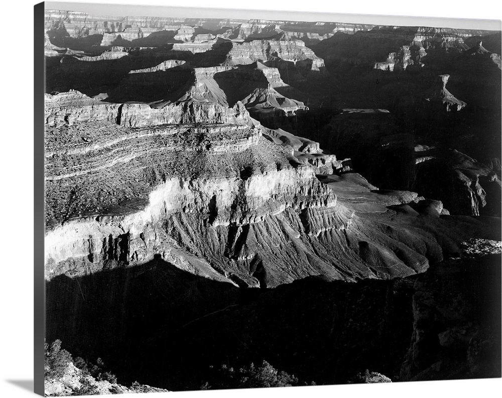 Grand Canyon National Park, panorama, dark shadows in foreground and right framing cliffs at left and center.