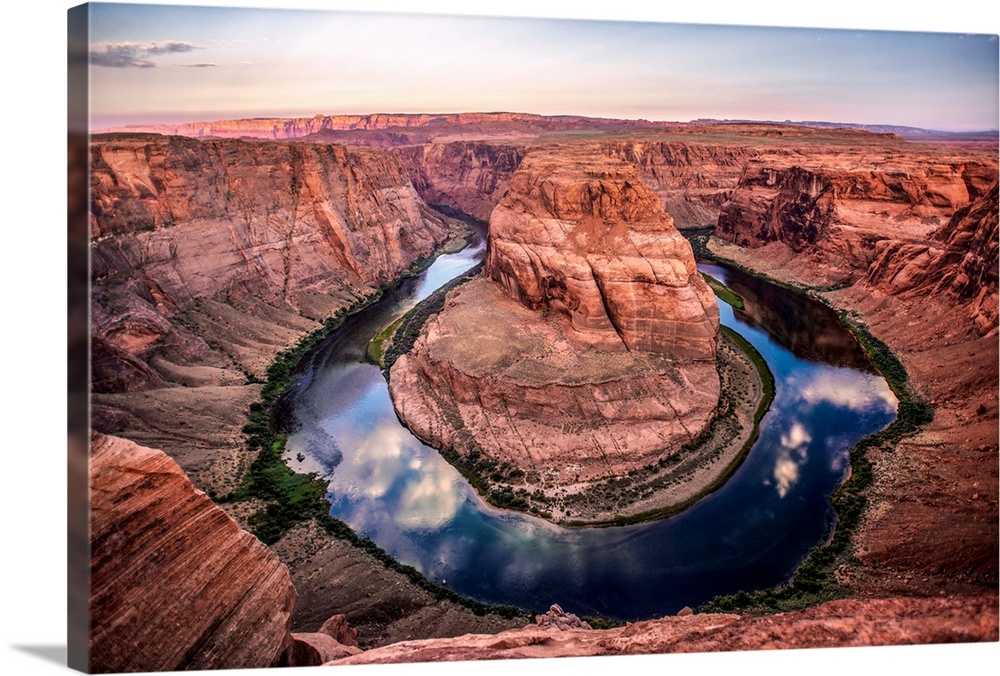 Landscape photograph of Horseshoe Bend in Page, Arizona with blue cloudy skies reflecting into the Colorado River.