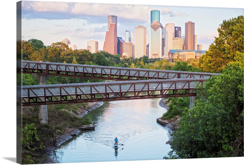 Photograph of the Houston TX skyline in the distance with the  Rosemont pedestrian bridge in the foreground over the Buffa...