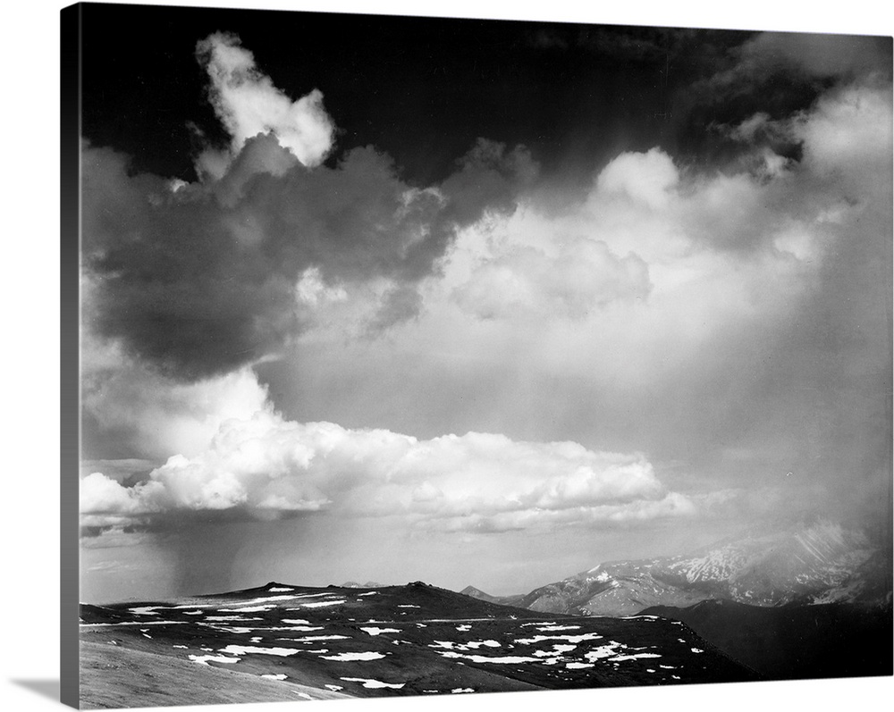 In Rocky Mountain National Park, mountain tops, low horizon, dramatic clouded sky.