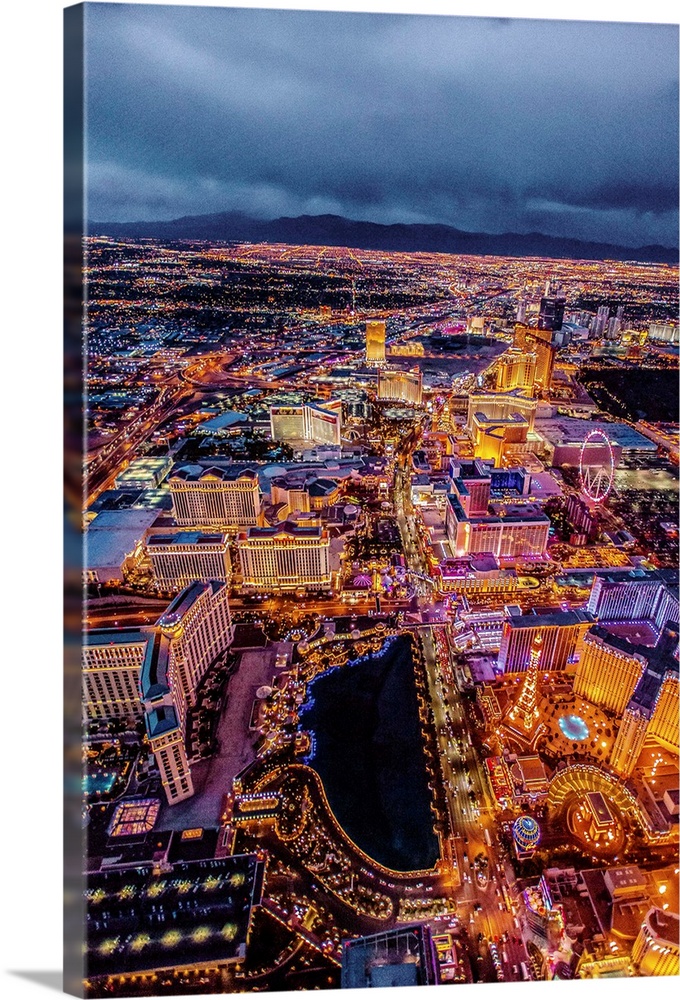 Aerial view of the Las Vegas Strip illuminated in the early evening with cloudy skies.