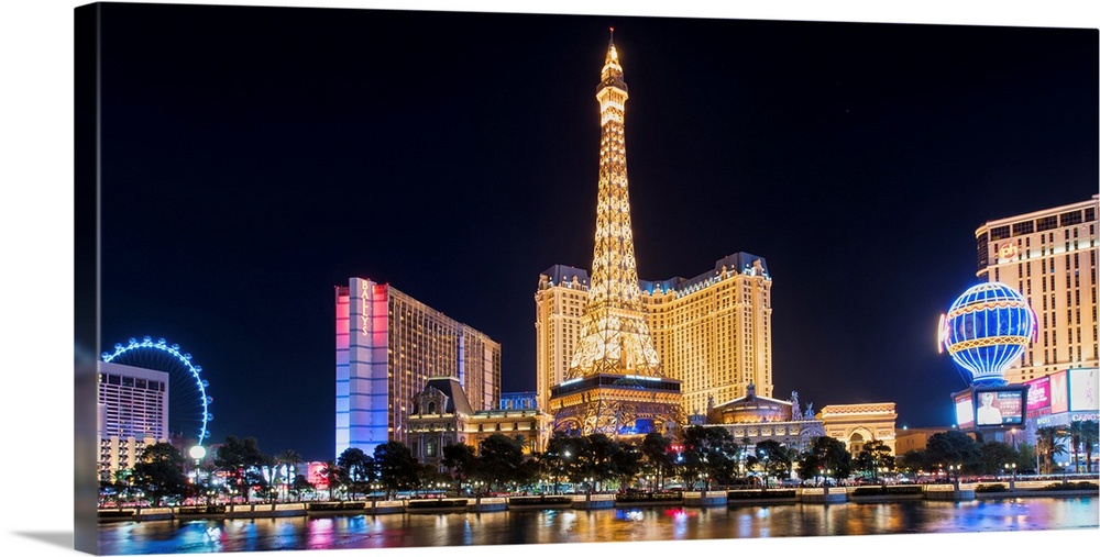 Panoramic photograph of the Las Vegas Strip lit up at night highlighting the Eiffel Tower Restaurant, hot air balloon, and...