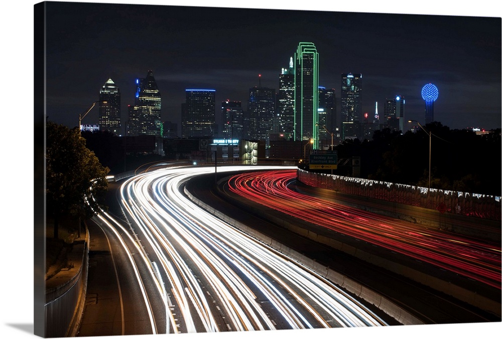 Light trails fill the foreground with Dallas skyline in the background.