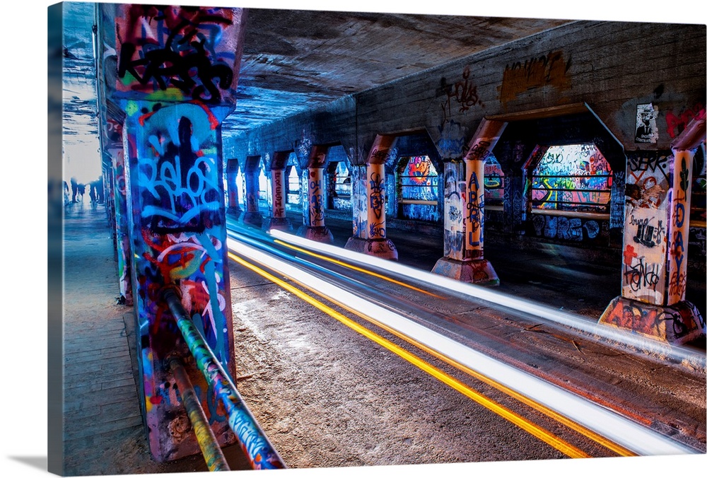 Light trails from passing cars create a bright glow, lighting up the graffiti on the walls and columsn in the Krog Street ...