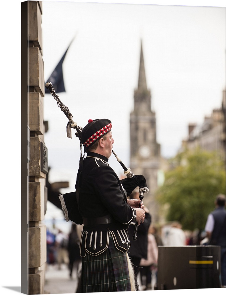 Photograph of a man playing bagpipes in the city of Edinburgh, Scotland, UK.