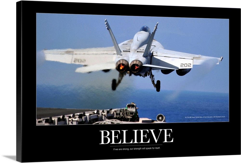 Large poster of a jet taking off from a ship with a black border around the picture and the word "Believe" under it.